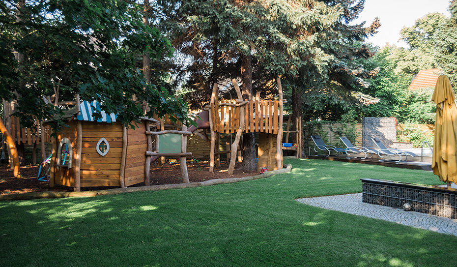 Rund um den bestehenden Pool sollte ein Spieleparadies für die Kinder und Entspannungsbereich für die Eltern entstehen. Ein Ort, an dem die Familie zusammenfindet und gemeinsam Zeit verbringen kann. Der Garten sollte individuell, detailverliebt, blütenreich sein und frisches Obst hervorbringen, damit die kleinen Naschkatzen eigens angebaute Leckereien pflücken können. Bereits im Herbst 2015 begannen die Gespräche und die Planungen, sodass nach dem Winter im März / April 2016 die Arbeiten begannen. Zu Beginn wurden Wurzeln entfernt und Leitungen und Kabel verlegt. Wege wurden geschaffen und gepflastert, Sitzplätze gestaltet und die Voraussetzungen für das Spiel- und Entdeckungsparadies hergestellt. Die Bauherren finden folgende Worte für unsere Arbeit und Leidenschaft: „Selbst zum Teil anhaltender Regen hielt Ihre Mitarbeiter nicht davon ab, den geplanten Fertigstellungstermin einzuhalten. Es war immer wieder eine Freude von der Arbeit nach Hause zu kommen und das neu Entstandene zu beobachten. Pünktlich zum Frühjahrsbeginn konnten dann die Arbeiten abgeschlossen werden und wir konnten unsere erste Familienfeier im neu gestalteten Garten durchführen. Alle waren begeistert. Nun sind die ersten Monate vergangen. Überall blüht es in den unterschiedlichsten Farben. Das erste Obst und Gemüse konnte geerntet werden und wir haben bereits viele Stunden der Erholung auf unserem Grundstück genießen können. Die Kinder nutzen den Rundweg als Rallye-Strecke mit ihren Tretautos und stellen Rundenrekorde auf. Wir möchten uns an dieser Stelle noch einmal ganz herzlich für Ihr Engagement und die tolle Arbeit bedanken. Aus heutiger Sicht würden wir jeder Zeit wieder ein derartiges Projekt mit Ihnen realisieren.“ Wir wünschen den Bauherren immer glücklich tobende Kinder und Zeit, das Familienleben zu genießen!